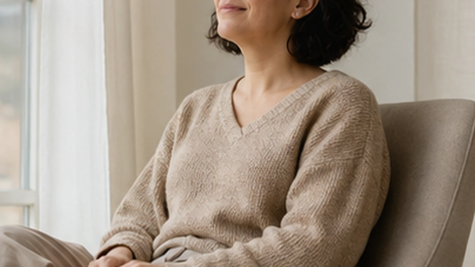 Person seated comfortably with relaxed shoulders in a quiet room