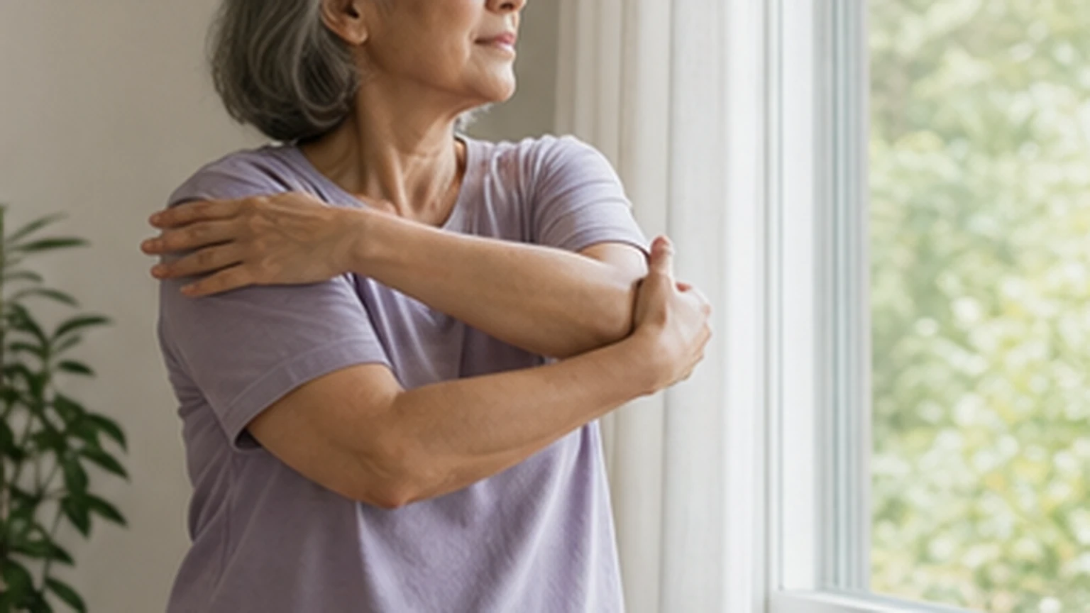 Older adult doing gentle shoulder mobility near a window