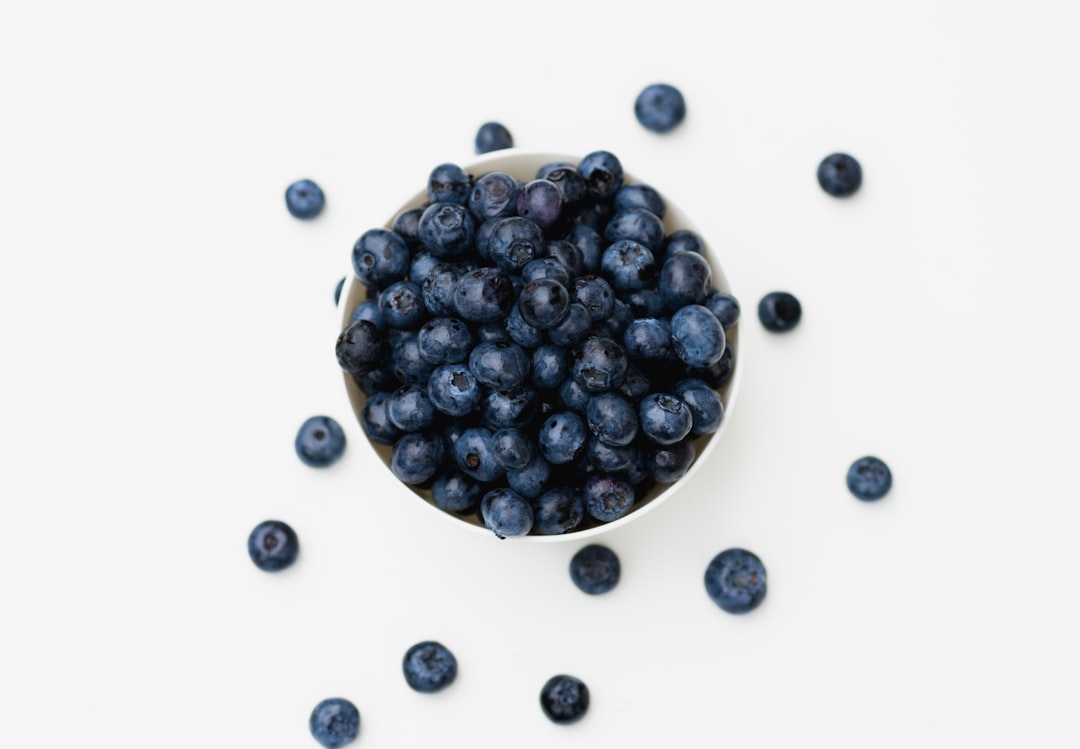 a-white-bowl-filled-with-blueberries-on-top-of-a-table-gfbizfplaek